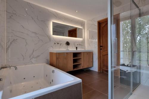 une salle de bain avec une baignoire, un lavabo et un miroir dans l'établissement 83AVEN - Mas de LAven, à Lorgues