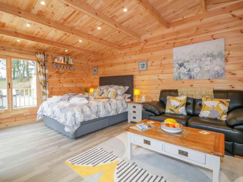 a living room with a bed and a couch at Little Orchard Lodge in Truro
