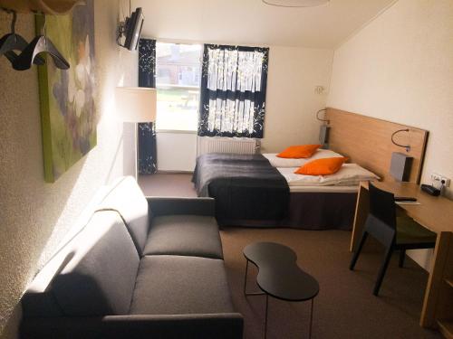 a small room with a bed and a couch at Best Western Hotel Hillerød in Hillerød