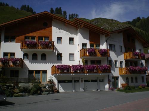 a large white building with balconies and flowers on it at Haus Viola in Samnaun