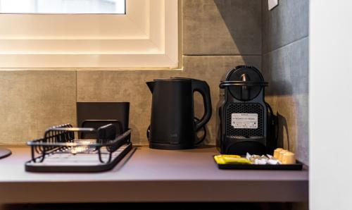 a counter top with a coffee maker and affeepot at Arches Apartments in Athens