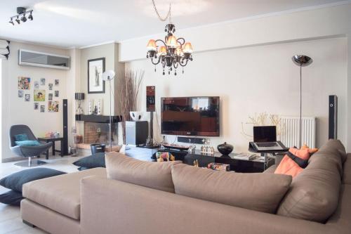a living room with a couch and a television at Designers apartment in Galatsi area in Athens