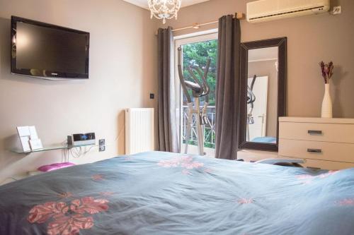 a bedroom with a bed and a tv and a window at Designers apartment in Galatsi area in Athens