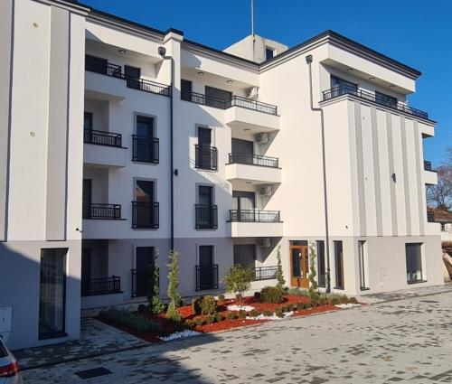 a white building with black windows and balconies at Moj Mir in Vrnjačka Banja