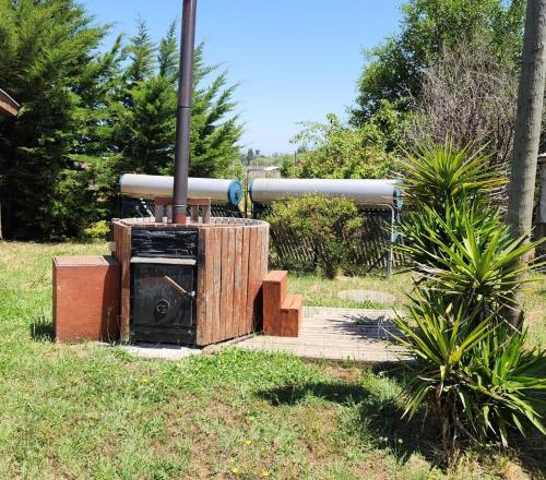 a wood stove sitting in the grass in a field at Spa, piscina y cabañas Tierra Mar in La Montaña