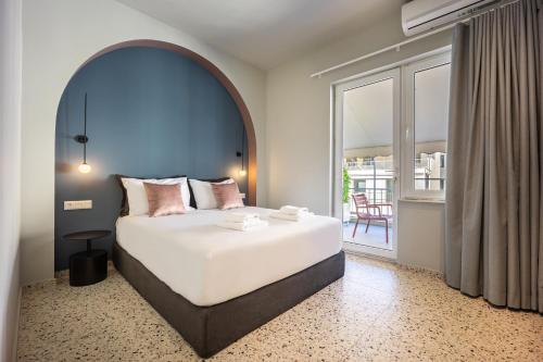 a bedroom with a large bed and a large window at Arches Apartments in Athens