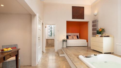 a bathroom with a tub and a bedroom with a bed at VILLA LAGUNA 10, Emma VIllas in Faenza
