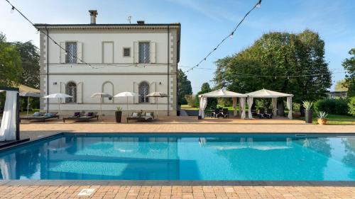 a villa with a swimming pool in front of a building at VILLA LAGUNA 10, Emma VIllas in Faenza
