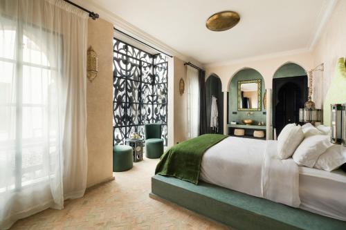 a bedroom with a bed and a large window at Riad Dar Acsameda & Spa in Marrakech