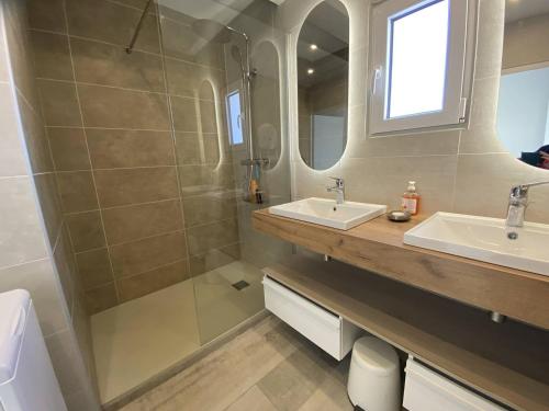 une salle de bain avec deux lavabos et une douche dans l'établissement PLEIN SUD 2 VUE MER, à Narbonne-Plage