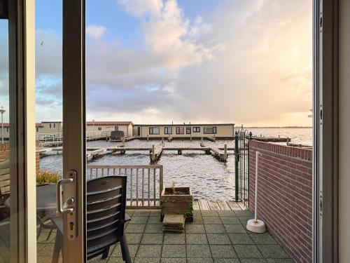 a door to a balcony with a view of the ocean at VISSERSLUST Rooms, Apartments and Houseboats in Vinkeveen