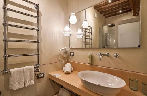a bathroom with a sink and a mirror at Saturnalia Village Rooms in Saturnia