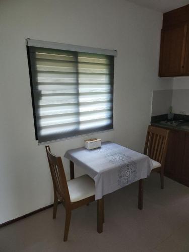 a table and chairs with a window in a kitchen at Avanta in Ban Mae Nam