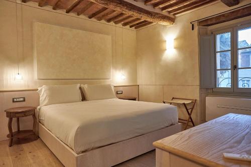a bedroom with a large white bed and a window at Saturnalia Village Rooms in Saturnia