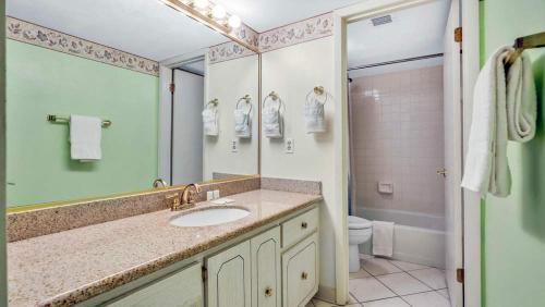 a bathroom with a sink and a toilet at Relaxing Ocean Condo Steps from the Beach in Daytona Beach Shores