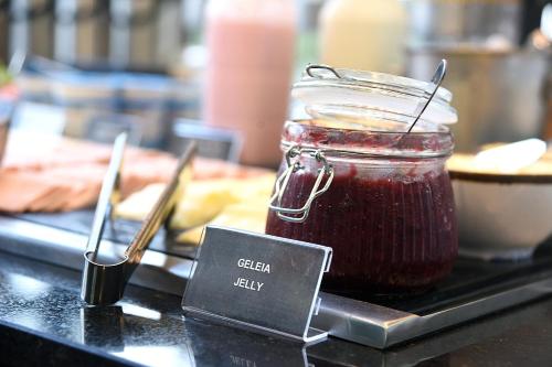 a jar of jam on a table with a sign at ibis Tangará Da Serra in Tangara da Serra