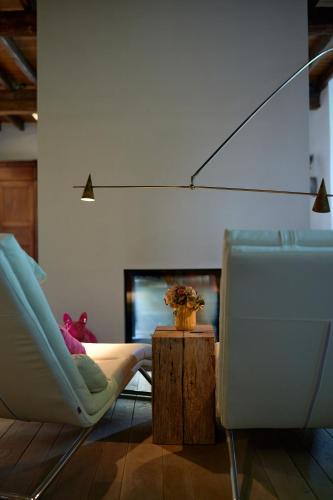 a living room with two chairs and a television at Broekemmolen - Nature getaway & green spot in Bilzen