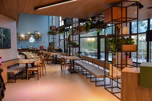 a restaurant with tables and chairs and windows at ibis Tangará Da Serra in Tangara da Serra