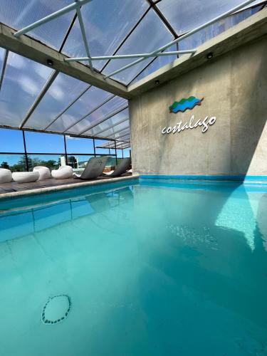 a pool of water with a sign on the side of a building at Costalago Suites Hotel in Villa Carlos Paz