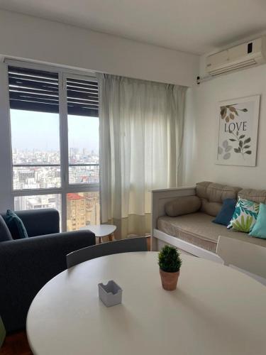 Piso 24 vista al Obelisco في بوينس آيرس: غرفة معيشة بها أريكة وطاولة