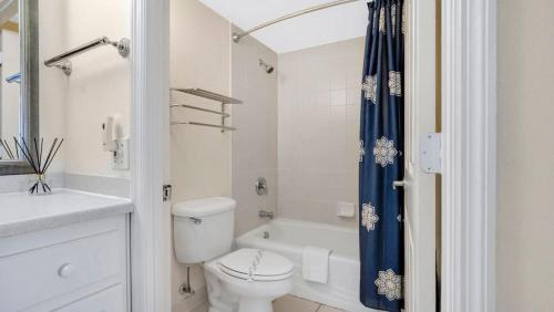 Un baño blanco con inodoro y ducha. en Daytona Beach Getaway with Direct Ocean Views, en Daytona Beach
