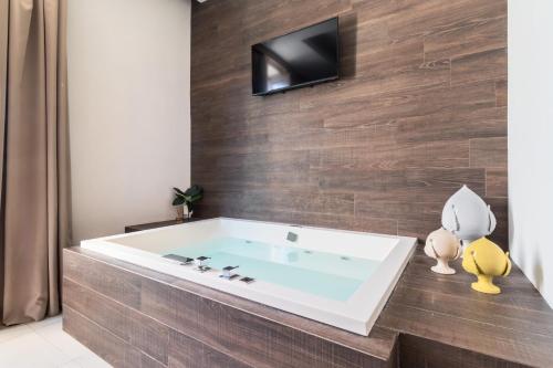 a bath tub with a television on a wall at Palazzo San Lazzaro - Jacuzzi Rooms & Suites Lecce Selection in Lecce
