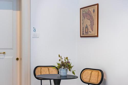 a table with two chairs and a table with a plant at Palazzo San Lazzaro - Jacuzzi Rooms & Suites Lecce Selection in Lecce
