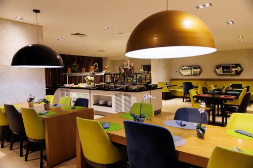 a restaurant with tables and chairs and a kitchen at Riviera Royal Hotel in Conakry