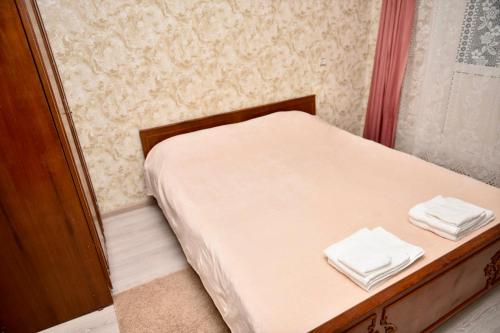 a small bed with two towels on top of it at Двокімнатна квартира, Харківська, 25 in Sumy