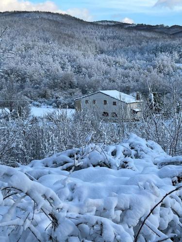 ein schneebedecktes Feld mit einem Haus im Hintergrund in der Unterkunft Il Cottage in Castel di Sangro