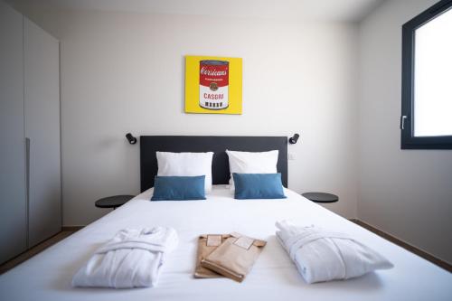 a bedroom with a bed with two bags on it at Residence Saletta Mare in LʼÎle-Rousse