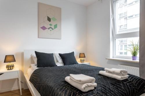 a bedroom with a bed with two towels on it at Urban Chic - Luxury 2-Bedroom Apartment in Warsaw City Center, Pereca Street in Warsaw