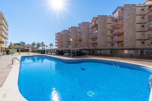 une grande piscine bleue en face de certains bâtiments dans l'établissement Mediterranean Way - Paradis Park, à La Pineda