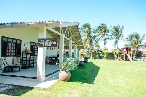 a house with a sign on the front of it at Recanto Preocupação Zero in Morro Branco