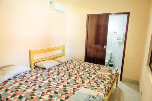 a small bedroom with a bed and a shower at Recanto Preocupação Zero in Morro Branco