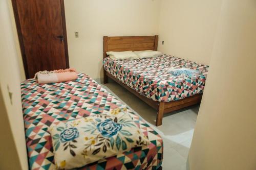 two beds in a small room with at Recanto Preocupação Zero in Morro Branco