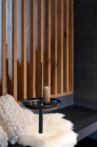 a black table with a wooden candle on a white rug at Chalet Waldzauber Your Alpine Escape in Bad Kleinkirchheim Near the Ski Lift in Bad Kleinkirchheim