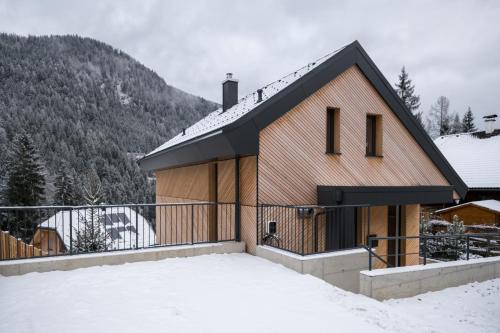 a house in the snow with mountains in the background at Chalet Waldzauber Your Alpine Escape in Bad Kleinkirchheim Near the Ski Lift in Bad Kleinkirchheim