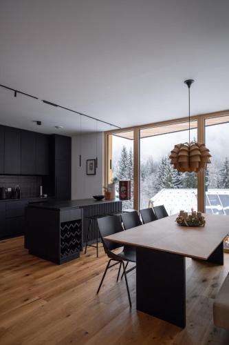 a dining room and kitchen with a table and chairs at Chalet Waldzauber Your Alpine Escape in Bad Kleinkirchheim Near the Ski Lift in Bad Kleinkirchheim