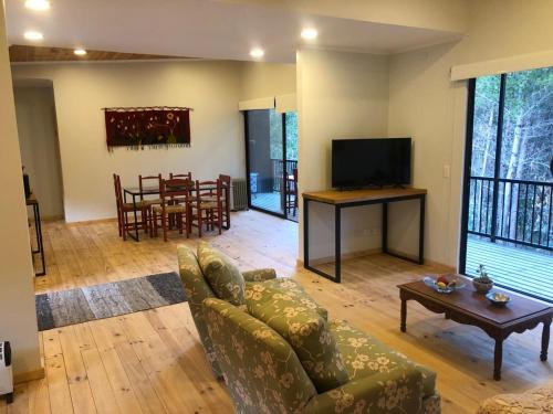 a living room with a couch and a television and a table at Hermosa casa en el bosque in Algarrobo