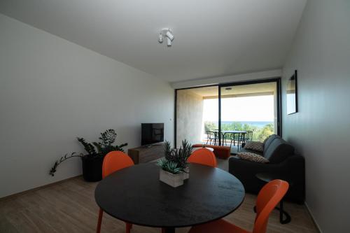 a living room with a table and a couch at Residence Saletta Mare in LʼÎle-Rousse