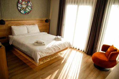 a bedroom with a bed and a chair and windows at Glitz Bodrum in Bodrum City
