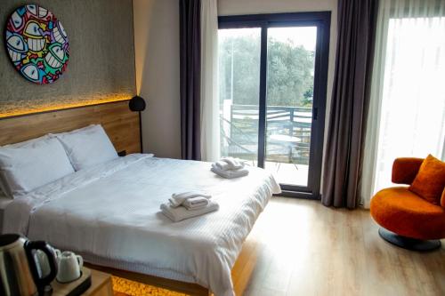 a bedroom with a bed and a chair and a window at Glitz Bodrum in Bodrum City