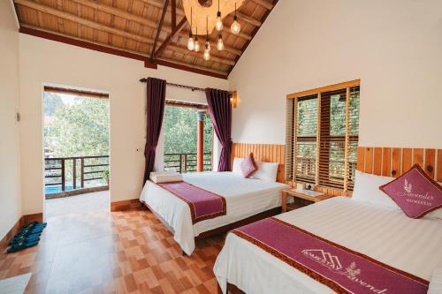 two beds in a room with two windows at Tam Coc Lavender Homestay -Authentic Ninh Binh Experiences in Ninh Binh