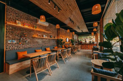 a restaurant with wooden tables and chairs and a brick wall at Tam Coc Lavender Homestay -Authentic Ninh Binh Experiences in Ninh Binh