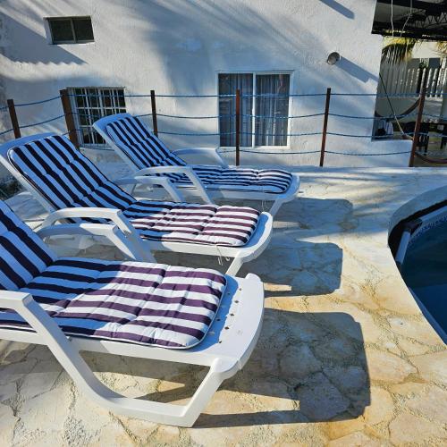 a group of lounge chairs sitting on a patio at Cabaña Los Cristales Coveñas by Amauna in Coveñas