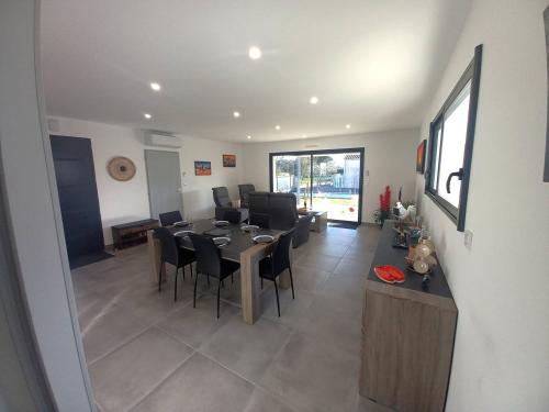 une salle à manger et un salon avec une table et des chaises dans l'établissement Saint Palais sur Mer - BELLES PRESTATIONS avec un TERRAIN DE PETANQUE - WIFI, à Saint-Palais-sur-Mer