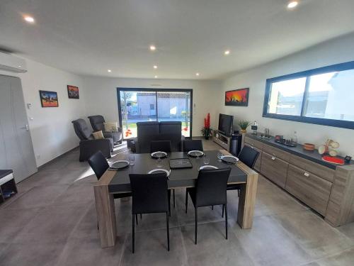 un salon avec une table et des chaises dans une pièce dans l'établissement Saint Palais sur Mer - BELLES PRESTATIONS avec un TERRAIN DE PETANQUE - WIFI, à Saint-Palais-sur-Mer