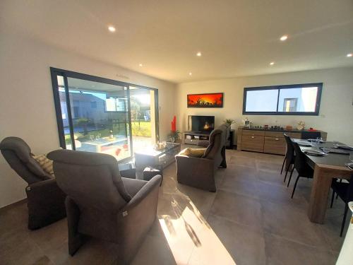 un salon avec une table, des chaises et une télévision dans l'établissement Saint Palais sur Mer - BELLES PRESTATIONS avec un TERRAIN DE PETANQUE - WIFI, à Saint-Palais-sur-Mer