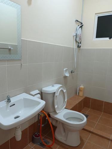 a bathroom with a white toilet and a sink at Seaview Emerald Sandakan in Sandakan